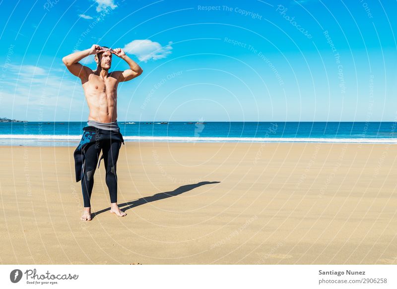 gutaussehender Schwimmer, der eine Brille aufsetzt. Bauchmuskeln attraktiv Strand schwarz Körper Kaukasier Taucher tauchen üben sportlich Fitness Brillenträger