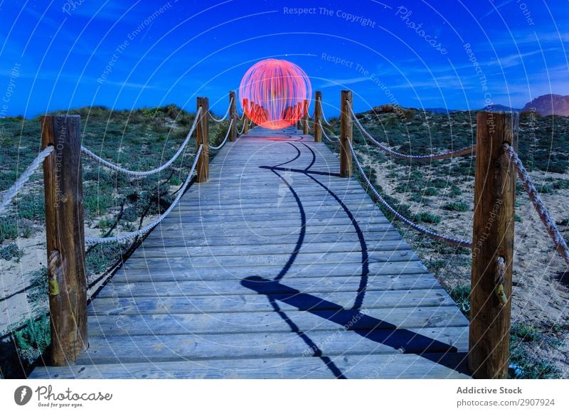 Abstrakter Ball auf der Fußgängerbrücke zwischen den Ländern abstrakt schwebend Steg Landen Kugel rot Boden Hügel Himmel Himmel (Jenseits) blau Abend Design