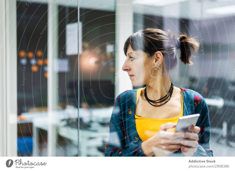 Frau beim Surfen auf dem Smartphone im Büro benutzend PDA Glas Wand Lächeln Erwachsene modern Pause Mobile Telefon Technik & Technologie Gerät Apparatur Browsen