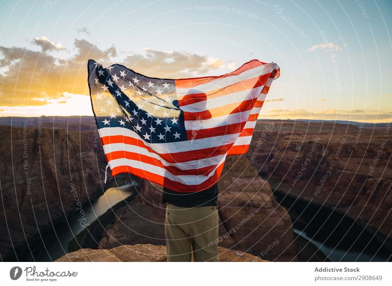 Anonymer Mann mit USA-Flagge in der Nähe des Canyons Fahne winkend Schlucht Fluss Ferien & Urlaub & Reisen Himmel Sonnenuntergang Westküste Klippe Abenteuer