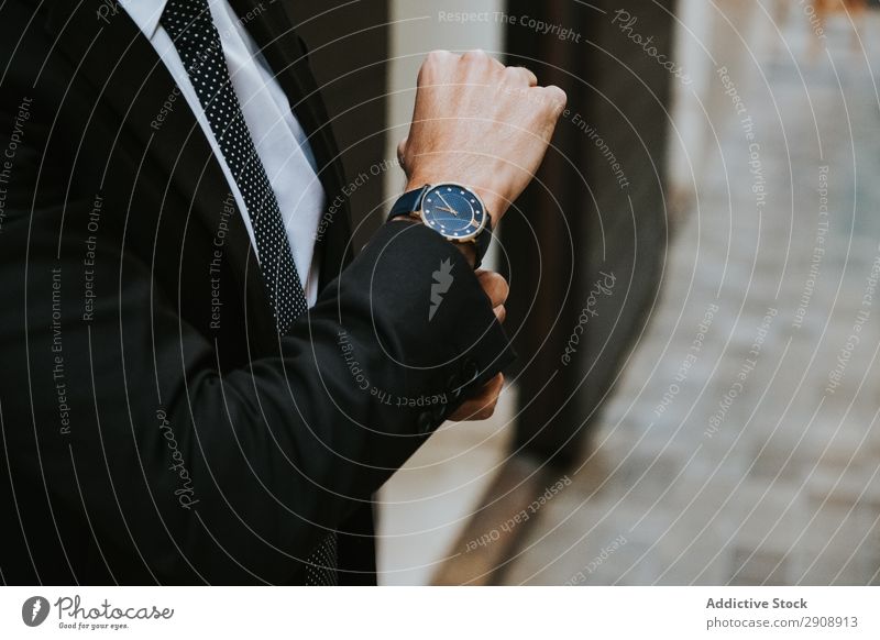 Junger stilvoller Mann im Kostüm mit Uhr Geschäftsmann beobachten elegant zeigen Anzug formell Jugendliche Stil Zeit professionell Erfolg Chef ernst Accessoire