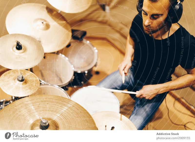 Mann mit Kopfhörern spielt am Schlagzeug Trommel Spielen positiv gutaussehend Studioaufnahme Musik professionell Jugendliche Schlagzeuger Gerät Rhythmus Klang