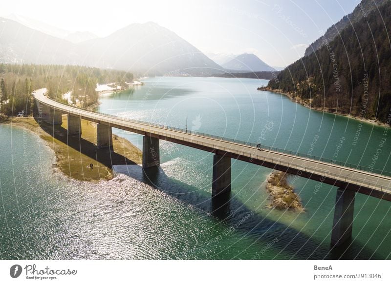 Eine Brücke, die einen See in den bayerischen Alpen überspannt Antenne Air Bayern Strand Wegbiegung Vogelschau Damm Dröhnen Wald Deutschland grün Wahrzeichen