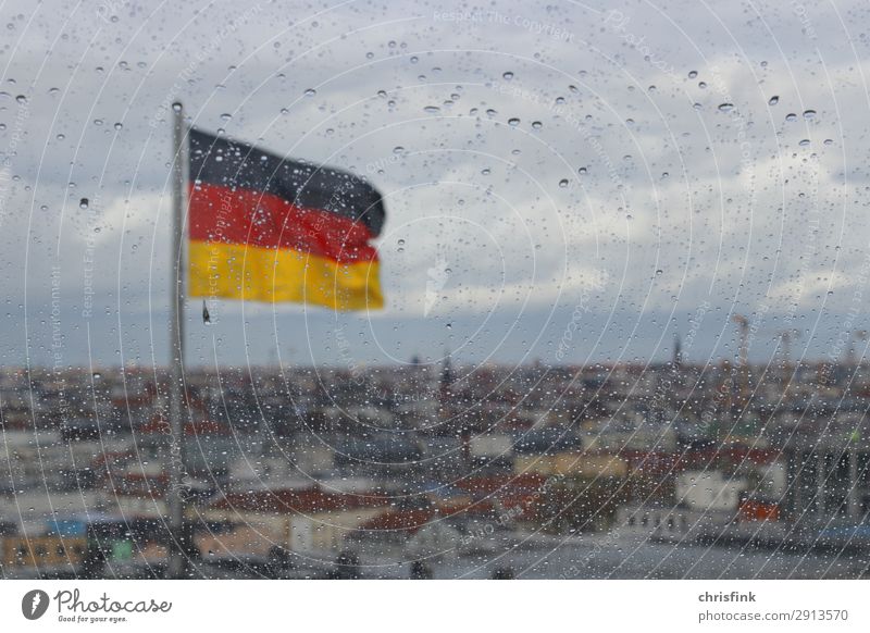 Deutsche Flagge hinter Tropfen auf Glasscheibe in Berlin Wolken Regen Hauptstadt Skyline Dach retro trist Traurigkeit Farbfoto Innenaufnahme Menschenleer