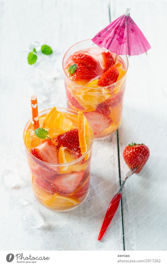 Zwei Gläser mit fruchtiger Erfrischung Frucht Orange Erdbeeren Zitronenmelisse Bioprodukte Vegetarische Ernährung Getränk Erfrischungsgetränk Trinkwasser Glas