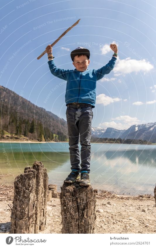 Kind steht mit Holzstock auf einem Holzstamm bei einem See Freizeit & Hobby Ausflug Abenteuer Freiheit wandern Kindheit 1 Mensch 3-8 Jahre Natur Landschaft