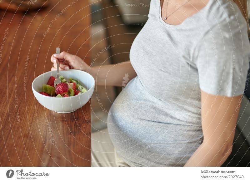 Schwangere Frau isst eine Schüssel Obstsalat mit frischen Erdbeeren Frucht Ernährung Essen Diät Schalen & Schüsseln Lifestyle Glück schön Erwachsene Mutter