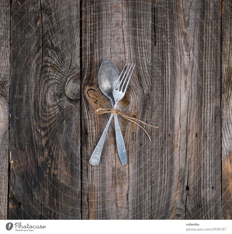 alte Metallgabel und Löffel, die mit einem braunen Seil gebunden sind. Abendessen Besteck Gabel Tisch Küche Restaurant Holz grau Kulisse Lebensmittel rustikal