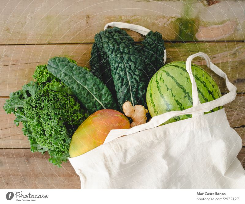 Stofftasche mit Gemüse auf Holzuntergrund. Frucht Ernährung Bioprodukte Vegetarische Ernährung Diät Lifestyle Sommer Tisch Küche Blatt Nutzpflanze Tasche
