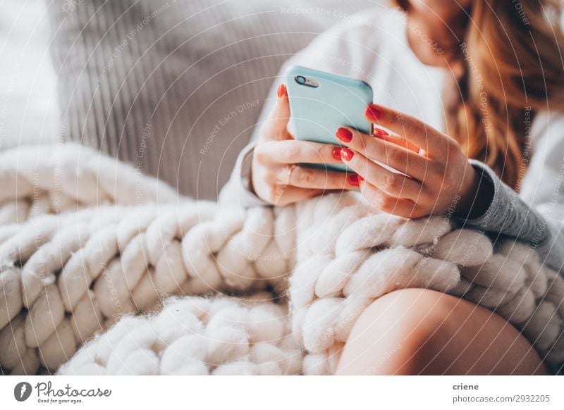 Frau auf der Couch sitzend mit Wolldecke und Smartphone Lifestyle Design Glück schön Erholung Freizeit & Hobby Winter Haus Telefon PDA Technik & Technologie