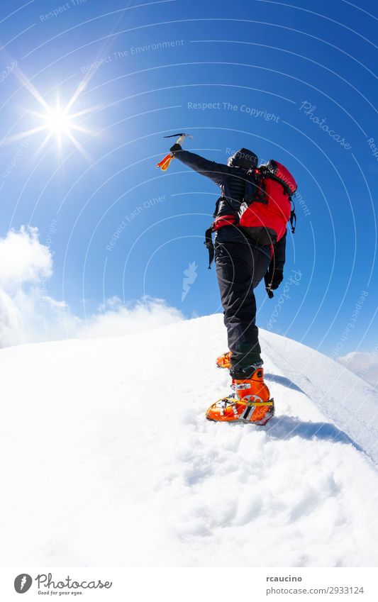 Der Kletterer erreicht den Gipfel eines schneebedeckten Berges. Freude Ferien & Urlaub & Reisen Abenteuer Freiheit Expedition Sonne Winter Schnee