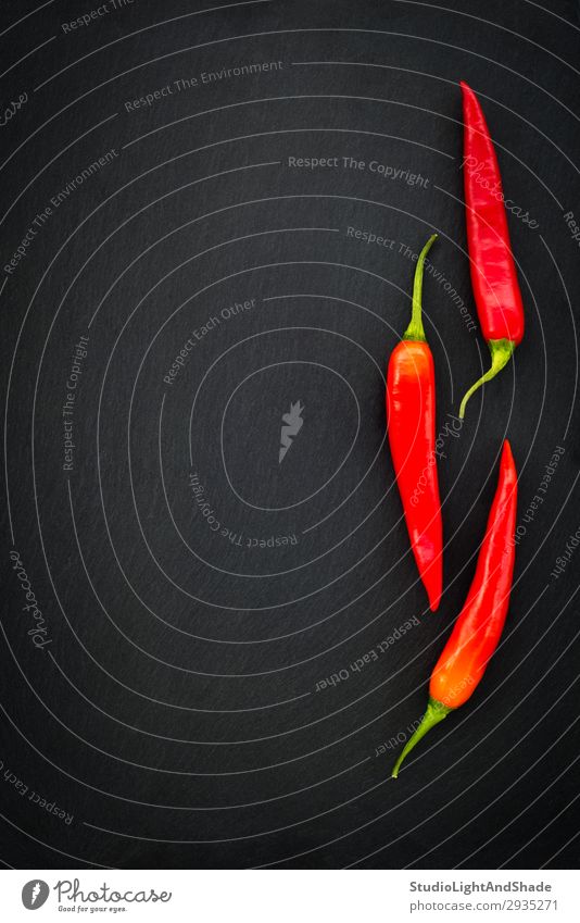 Drei rote Chilischoten auf dunklem Hintergrund Gemüse Kräuter & Gewürze Essen Vegetarische Ernährung Gesunde Ernährung dunkel einfach frisch heiß kalt natürlich
