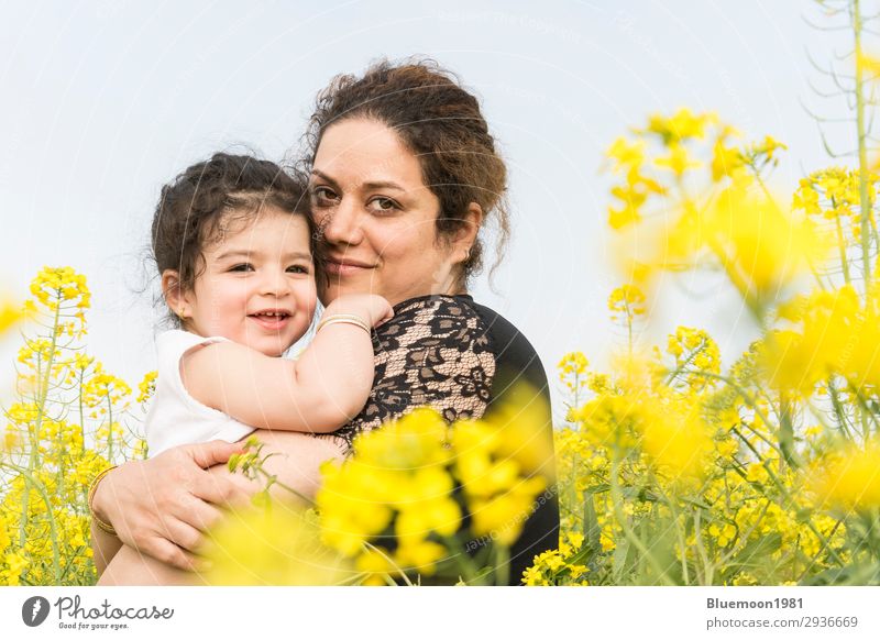 Junge glückliche Mutter umarmte ihr süßes kleines Mädchen auf dem Rapsfeld Lifestyle Freude schön Wohlgefühl Abenteuer Sommer Muttertag Kindererziehung