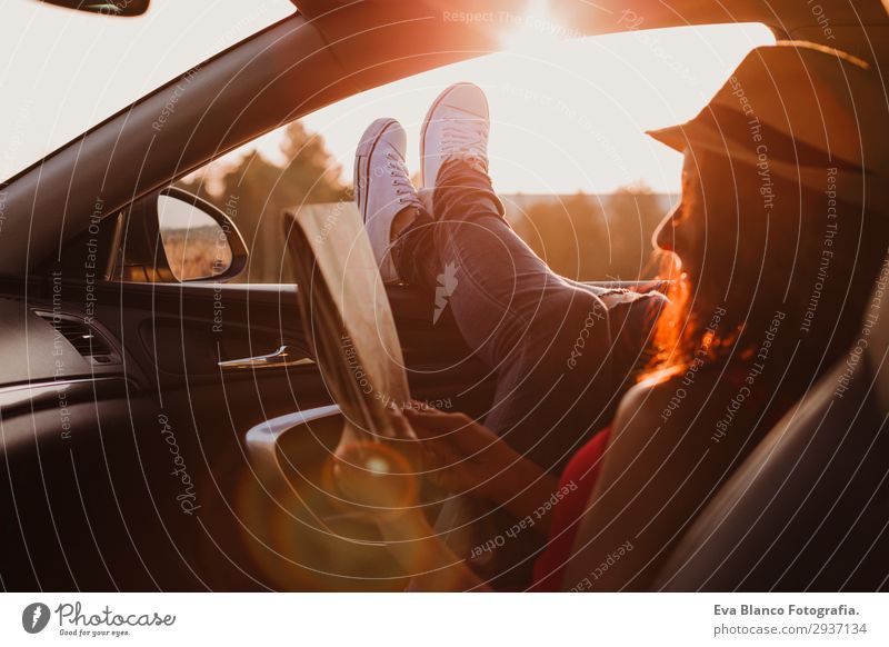 Modernes Mädchen ruht bei Sonnenuntergang in einem Auto. Lifestyle Freude Erholung lesen Ferien & Urlaub & Reisen Ausflug Abenteuer Sommer feminin Junge Frau