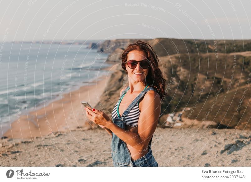 Porträt einer schönen, glücklichen jungen Frau im Freien Lifestyle Glück Erholung Ferien & Urlaub & Reisen Sommer Sonnenbad Strand Meer sprechen Telefon