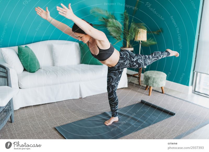 Frau, die zu Hause Yoga-Übungen mit der Yogamatte macht. Freizeit & Hobby Wohnzimmer Sport Erwachsene Fitness ausarbeitend heimwärts Gesundheit passen Aktion