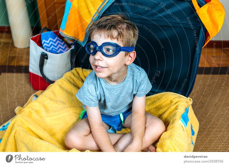 Lustiger Junge lächelnd in einem Koffer sitzend. Lifestyle Freude Schwimmbad Freizeit & Hobby Ferien & Urlaub & Reisen Ausflug Sommer Strand Kind Mensch Mann