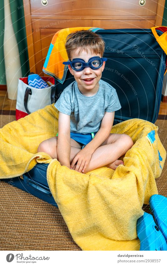 Lustiger Junge lächelnd in einem Koffer sitzend. Lifestyle Freude Glück Schwimmbad Freizeit & Hobby Ferien & Urlaub & Reisen Ausflug Sommer Strand Kind Mensch