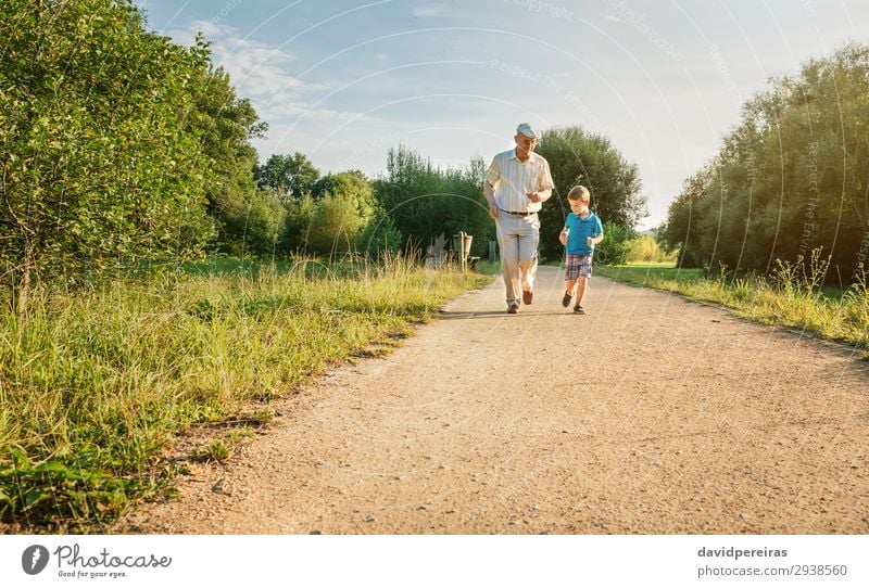 Älterer Mann und glückliches Kind laufen auf Naturpfad Freude Glück Freizeit & Hobby Spielen Sommer Mensch Junge Erwachsene Großvater Familie & Verwandtschaft