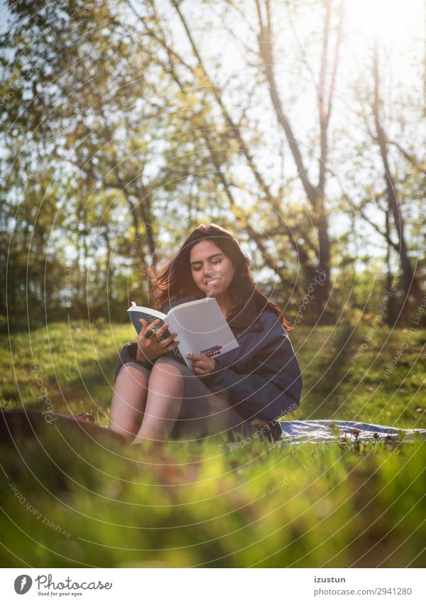 Schülerlesebuch im Park Freizeit & Hobby lesen Freiheit Sommer Frau Erwachsene Jugendliche Körper Haut Kopf Natur Baum Gras Jacke schwarzhaarig Lächeln Blick