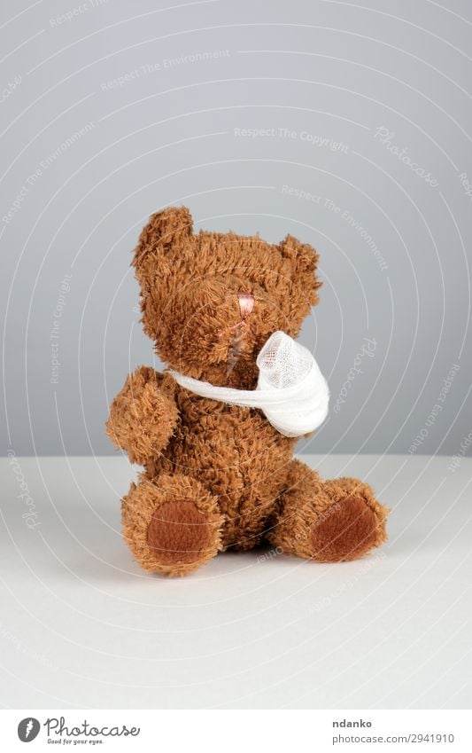 brauner Teddybär mit einer bandagierten Pfote Behandlung Krankheit Medikament Kind Krankenhaus Kindheit Arme Band Spielzeug sitzen klein lustig niedlich weiß