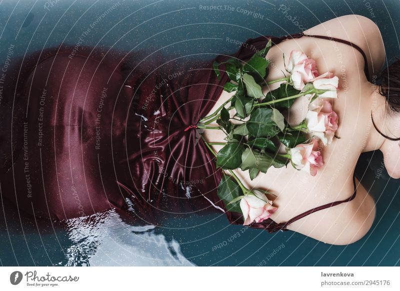Frauenrücken in violettem Kleid gefüllt mit Rosen, die in der Badewanne liegen. Schwimmen & Baden schön Beautyfotografie Blume Blüte blau