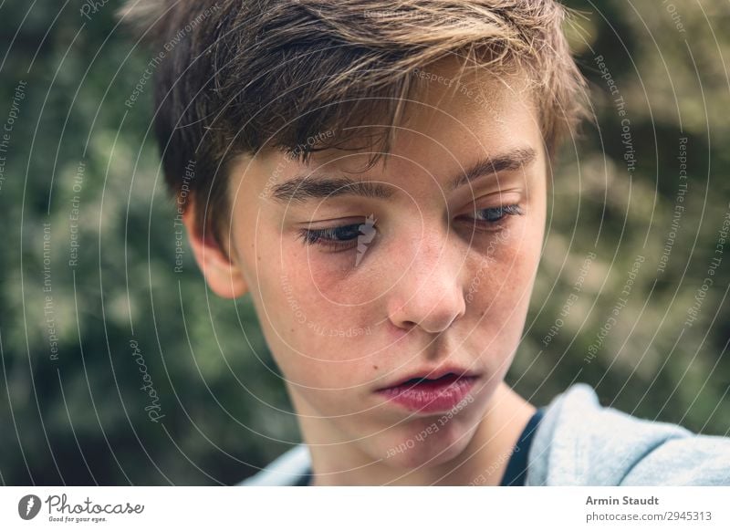 Porträt eines jungen Mannes, der gedankenverloren nach unten blickt besinnlich Teenager ernst nachdenklich Konzentration Blick Junge männlich schön lässig