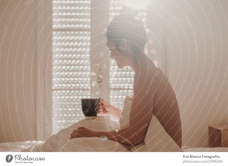 Frau im Bett bei einer Tasse Kaffee. Morgens Getränk Lifestyle Glück schön Körper Erholung Freizeit & Hobby Sonne Wohnung Haus Raum Schlafzimmer feminin