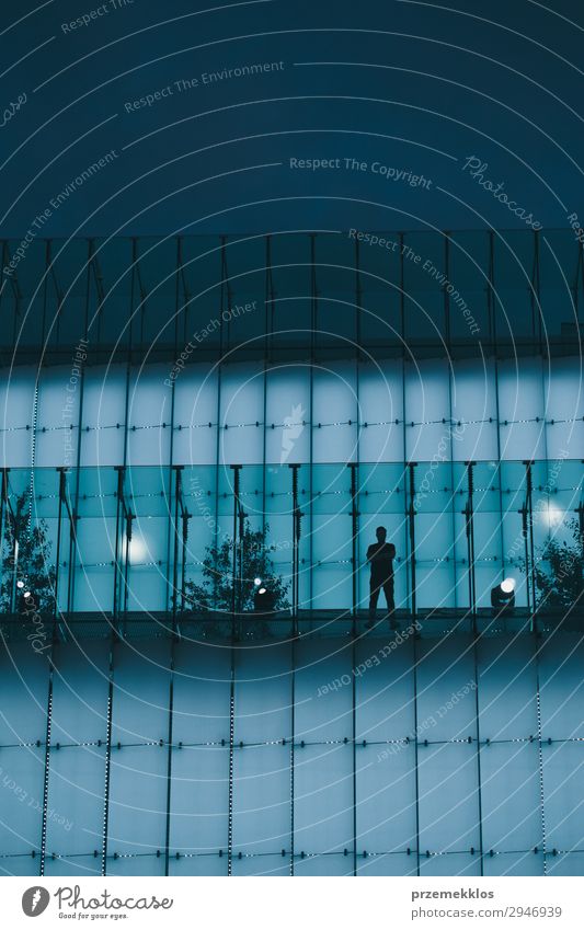Mann steht auf einer hinterleuchteten Glaskonstruktion in einem Stadtzentrum. Erwachsene Gebäude blau hintergrundbeleuchtet Zentrum Großstadt Konstruktion Licht