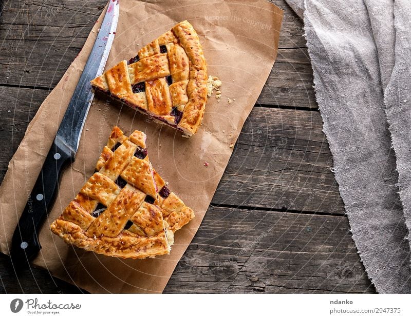 gebackene Kuchen mit einer Kirsche Frucht Dessert Marmelade Messer Tisch Papier Holz Essen frisch lecker oben braun rot Tradition Bäckerei Beeren Kruste