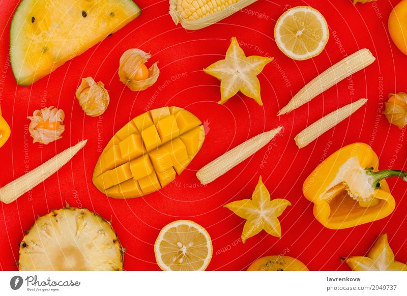 verschiedene gelbe und orange Früchte und Gemüse auf rot Klingel Karambole Zitrone Zitrusfrüchte Corny geschnitten flach frisch Gesundheit Gesunde Ernährung