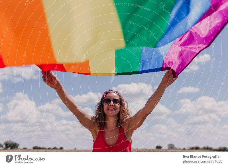 Frau hält die Gay Rainbow Flag über dem blauen Himmel im Freien. Lifestyle Freude Glück Freizeit & Hobby Freiheit Sommer Sonne Hochzeit Mensch feminin