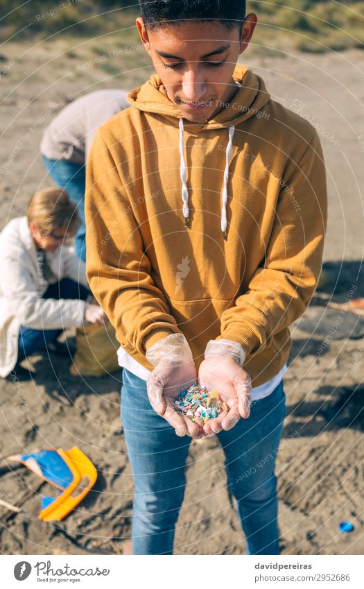 Junger Mann zeigt Mikrokunststoffe Strand Mensch Erwachsene Hand Menschengruppe Umwelt Sand Kunststoff alt gefährlich Teamwork Umweltverschmutzung