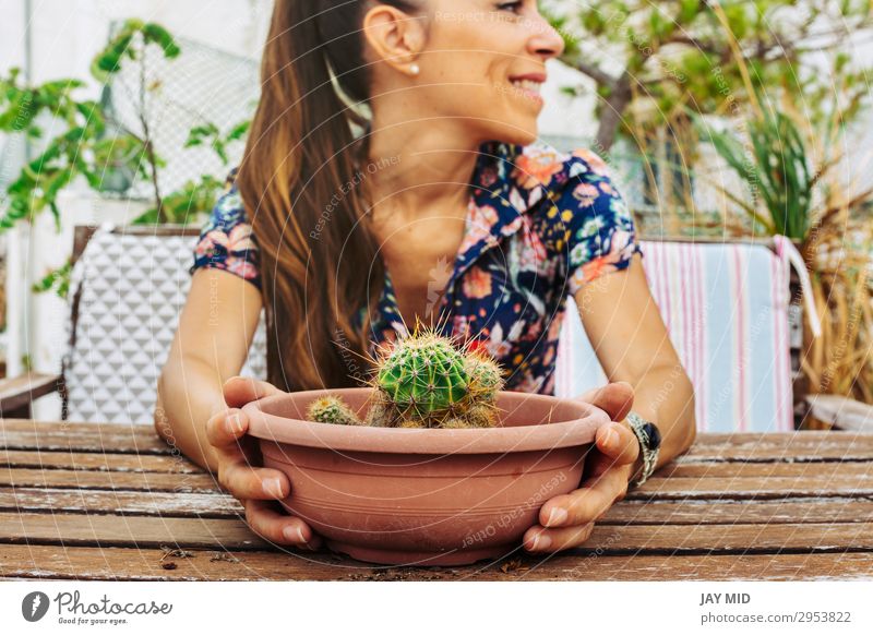 Nahaufnahme einer Frau, die einen Topf Kaktus auf der Terrasse hält. Lifestyle Sommer Garten Dekoration & Verzierung Tisch Gartenarbeit Mensch feminin