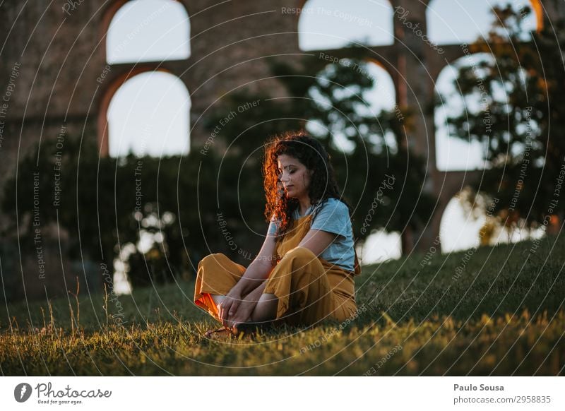 Junge Frau ruht sich bei Sonnenuntergang aus Lifestyle Wohlgefühl Erholung Meditation Mensch feminin Jugendliche 1 18-30 Jahre Erwachsene Natur Sommer Park