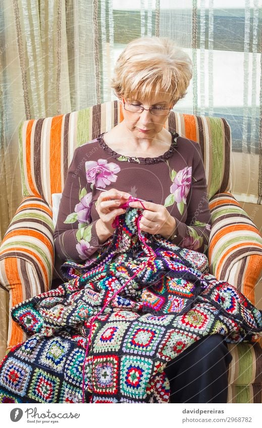 Porträt einer Frau, die eine alte Wolldecke strickt. Erholung Freizeit & Hobby stricken Arbeit & Erwerbstätigkeit Handwerk Mensch Erwachsene Mutter Großmutter