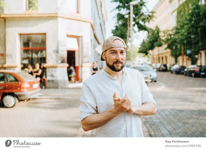 Mann mit Basecap auf der Straße stehend attraktiv Baseball Vollbart bärtig Verschlussdeckel lässig Kaukasier heiter Stadtleben selbstbewusst cool Emotion