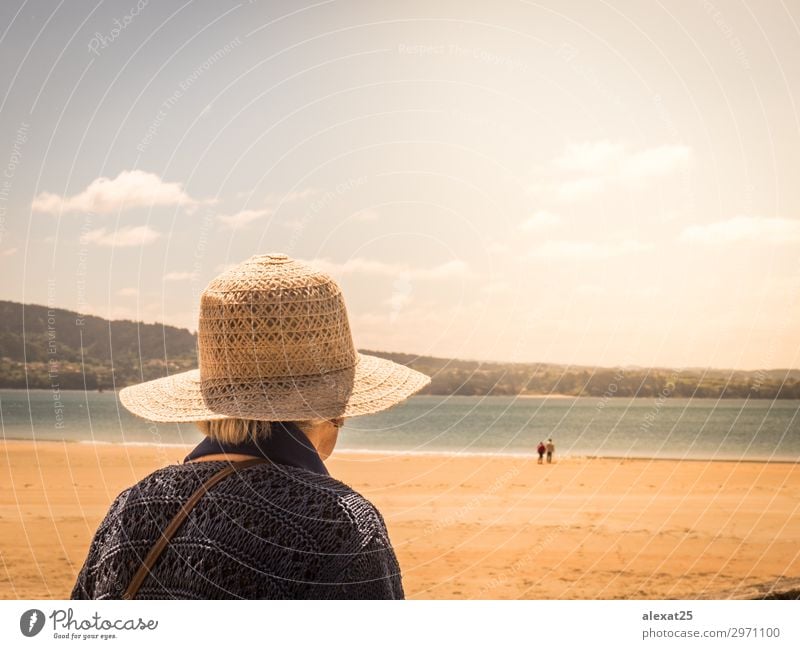 Unkenntliche alte Frau, die ein Paar an einem Strand ansieht. Lifestyle Glück schön Leben Sommer Sonne Meer Erwachsene Natur Himmel Liebe träumen Fröhlichkeit