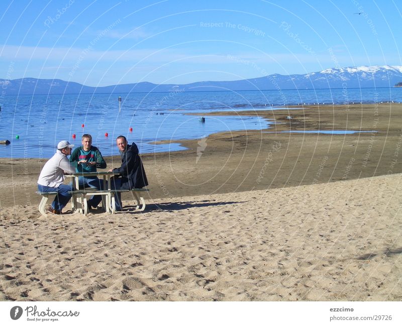 da stand ne bank am strand Strand See Kalifornien Nevada Bank sitzen Wasser lake tahoe USA Seeufer Sand Sandstrand Urlaubsfoto Ferne Tourist Berge u. Gebirge