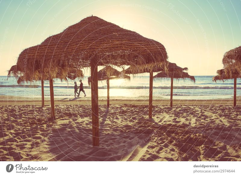 Holzschirme an einem Strand bei Sonnenuntergang exotisch schön Erholung Freizeit & Hobby Ferien & Urlaub & Reisen Tourismus Sommer Meer Insel Natur Landschaft