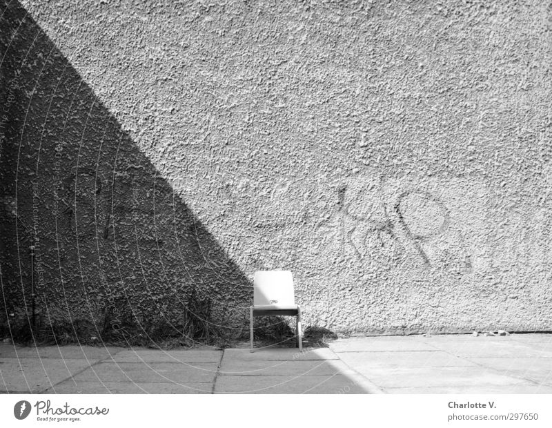 Stuhl Mauer Wand Beton Holz Schriftzeichen Graffiti stehen einfach retro grau schwarz weiß ruhig authentisch standhaft bescheiden Neugier Einsamkeit einzigartig