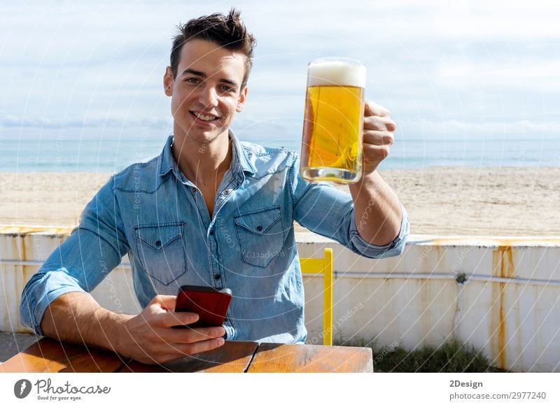 junger Mann, der auf einem Strandclub sitzt und Bier hält. Kaffee kaufen Sommer Tisch Club Disco Telefon PDA Mensch maskulin Erwachsene 1 13-18 Jahre