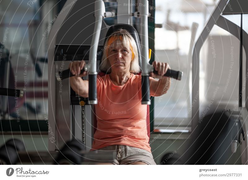 Eine ältere Frau übt Übungen auf einem Fitnesstrainer Sport Sport-Training Sportstätten Mensch feminin Erwachsene 1 45-60 Jahre blond schaukeln Senior Kaukasier