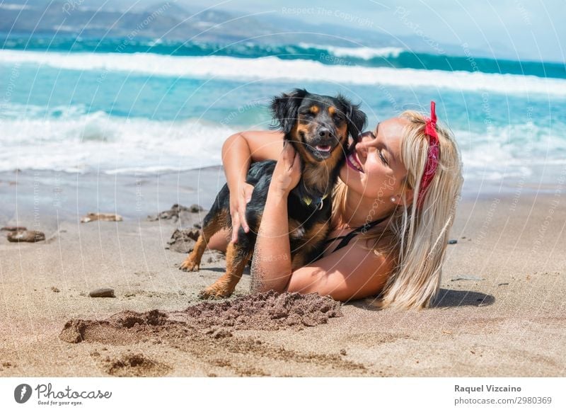 Frau, die ihren Hund am Strand umarmt. Lifestyle Wohlgefühl Ferien & Urlaub & Reisen Tourismus Sommer Sommerurlaub Sonnenbad Junge Frau Jugendliche Kopf Gesicht