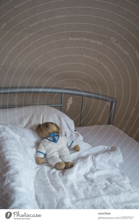 leeres bett mit einem alten teddybär Bett Bettdecke Kopfkissen Teddybär retro Eisenstange Bettgestell Wand Matratze Bettlaken weiß minimal schlafen