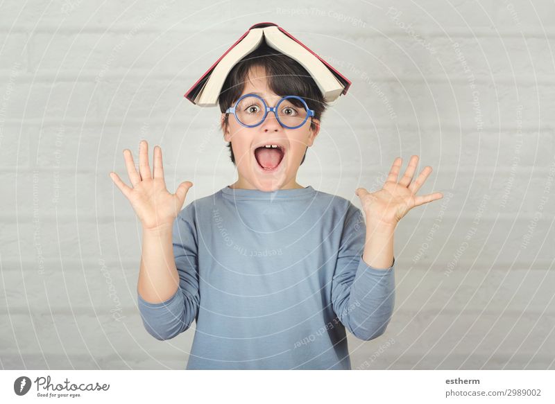 fröhliches und lächelndes Kind mit Buch auf dem Kopf Lifestyle Freude Spielen lesen Schule Schulkind Mensch maskulin Junge Kindheit 1 8-13 Jahre Fitness Lächeln
