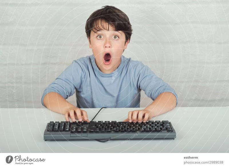 überraschtes Kind mit Tastatur Lifestyle Spielen Computer Software Technik & Technologie Unterhaltungselektronik Internet Mensch maskulin Kindheit 1 8-13 Jahre