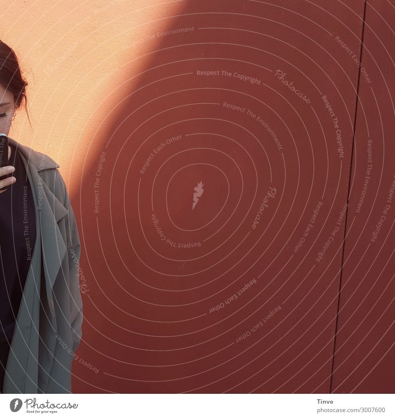 Frau mit Handy vor rötlicher Wand Junge Frau Jugendliche 1 Mensch 18-30 Jahre Erwachsene Mauer brünett Kommunizieren Information Informationsaustausch Aktion