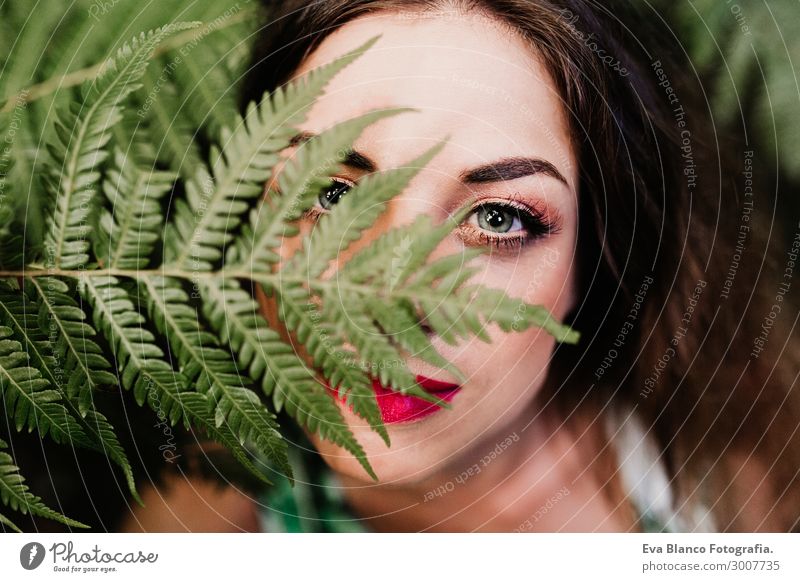 Nahaufnahme des Porträts einer jungen, schönen Frau unter grünem Farn Lifestyle Haut Gesicht Schminke Wellness Spa Freizeit & Hobby Garten feminin Junge Frau