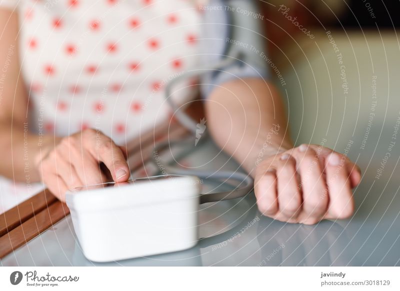 Frau, die zu Hause ihren eigenen Blutdruck misst. Gesundheitswesen Krankheit Medikament Prüfung & Examen Bildschirm Werkzeug Mensch feminin Erwachsene Arme Hand